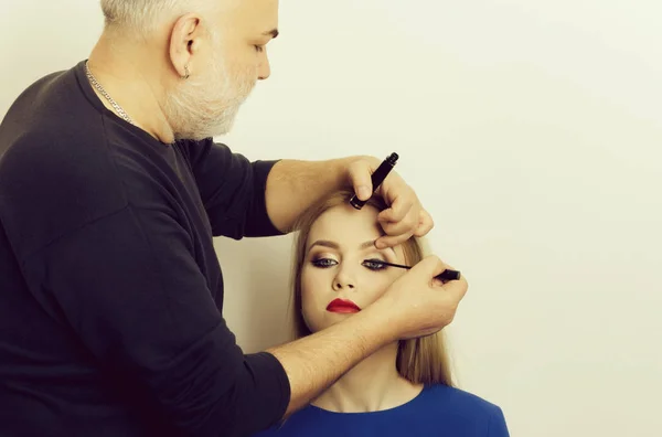 Maquillaje artista aplicar rímel negro en las pestañas de la chica — Foto de Stock
