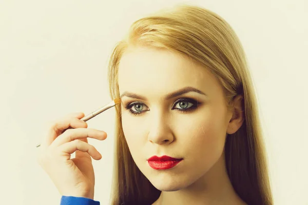 Model trägt Lidschatten mit Make-up-Pinsel auf — Stockfoto