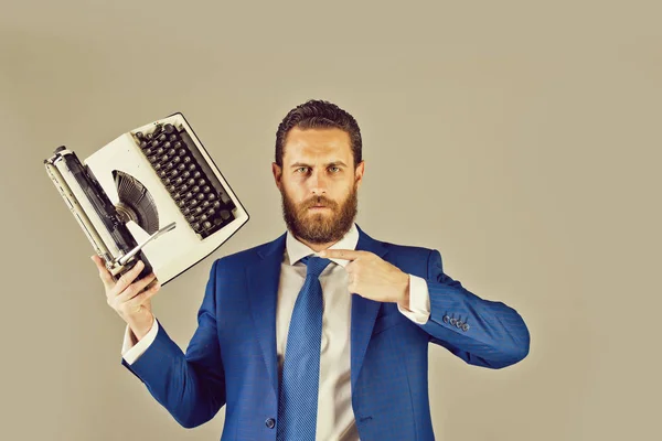 Homem de negócios em terno azul e gravata com máquina de escrever — Fotografia de Stock