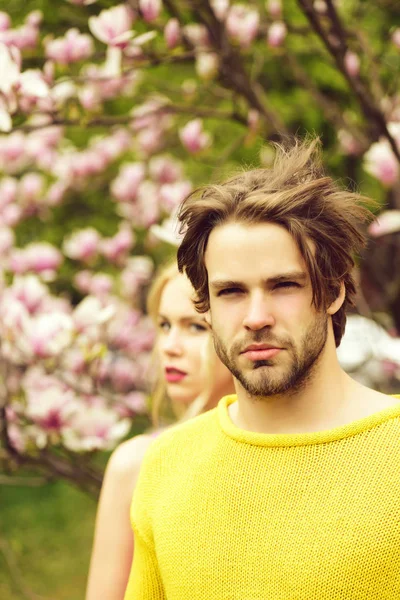 Hombre y mujer sobre fondo natural, jardín con flor de magnolia — Foto de Stock