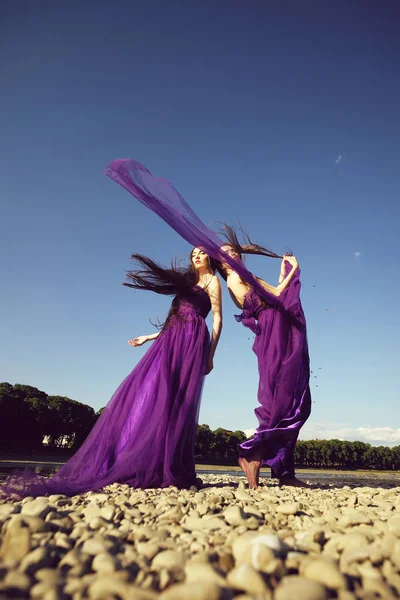 Жінки в фіолетових сукнях — стокове фото