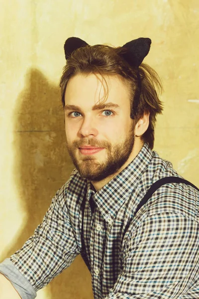 Man posing with black cat ears headband on head