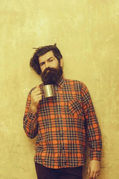 Нахмуренный бородатый мужчина с бородой держа металлическую кружку — стоковое фото