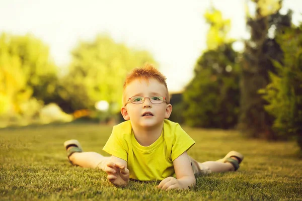 Çimenlerin üzerinde bardaklarda Kızıl saçlı erkek mutlu bebek