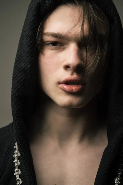 Retrato de close-up de adolescente vestindo capuz preto. Jovem com cabelo de comprimento médio e lábios cheios cantando rap, cultura hip hop e conceito de estilo juvenil — Fotografia de Stock