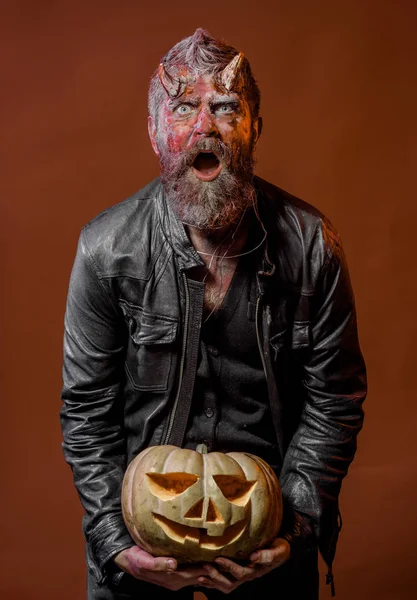 Halloween satan with beard, wounds, red blood on surprised face