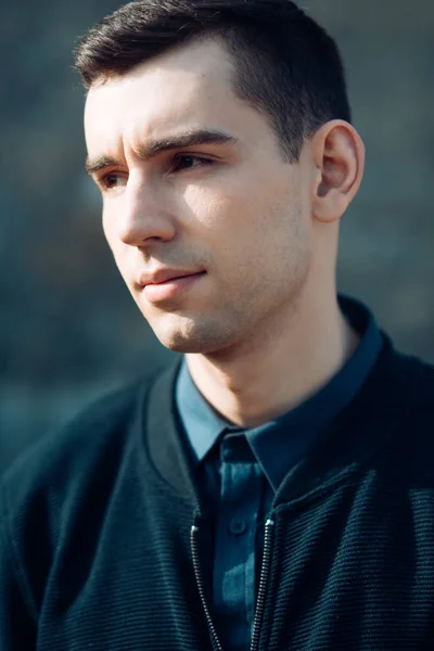 Knappe jonge man buiten. Portret van een jonge man met donkerbruine haren. lente en herfst mode. — Stockfoto