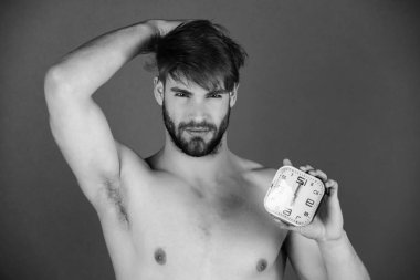 çalar saat elinde tutan adam