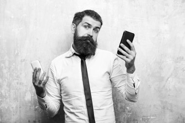 sakallı adam veya hipster karşılaştırmak hareket eden telefon ve smartphone