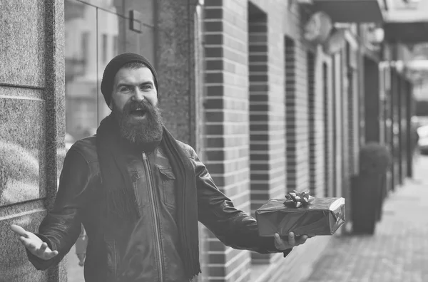 Happy bearded man hipster with present box in leather jacket — Stock Photo, Image