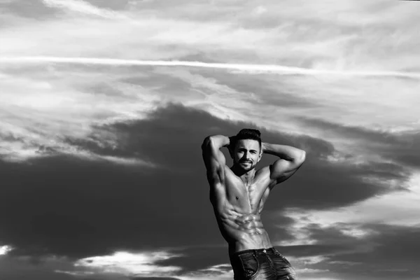 Hombre con cuerpo musculoso en el cielo azul — Foto de Stock