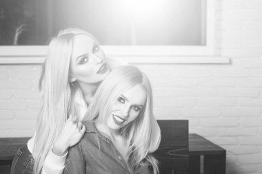 kucaklayan ve birlikte gülümseyen iki mutlu neşeli genç kadın