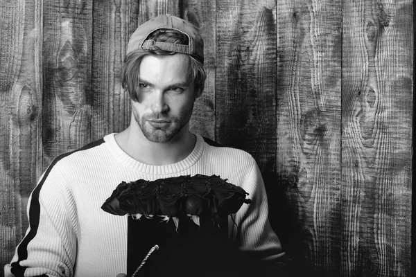 adam tutar kırmızı gül çiçekler kutusunda sakallı