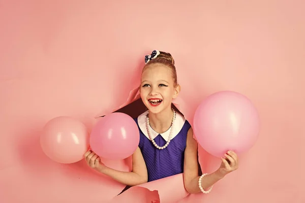 Skönhet och mode, slagkraftig pasteller. Liten flicka med frisyr håller ballonger. Snålt med ballonger på födelsedag. Liten flicka barn med party ballonger, firande. Födelsedag, lycka, barndom, titt. — Stockfoto