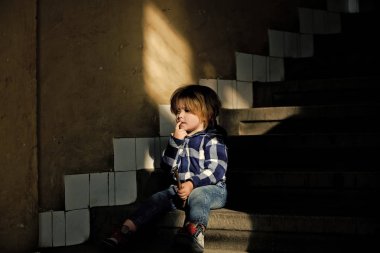 Yürümeye başlayan çocuk düşünme yüzü ile ev merdivenlerde otur