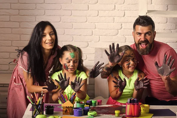 Famille heureuse montrant les mains colorées dans les peintures — Photo