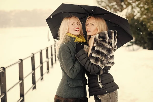 Mutlu kadın şemsiye altında kış gününde gülümseyen