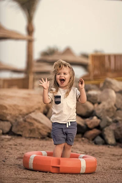 ビーチでオレンジ ライフ リングで笑っている小さな子供. — ストック写真