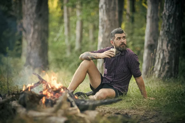 Hipster hiker kupa ile rahatla ormandaki şenlik ateşi