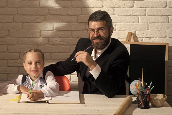Kız ve babası ve çalışma odası beyaz tuğla zemin üzerine. Aile, okul malzemeleri ile masada oturur. Kız öğrenci ve gülümseyen yüzler ile babası yazma öğrenmek. Sınıf ve ev eğitim kavramı