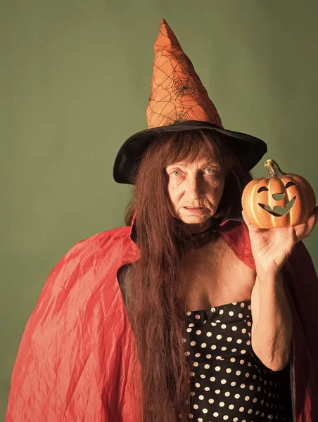 Mujer de Halloween sosteniendo la calabaza sobre fondo verde — Foto de Stock