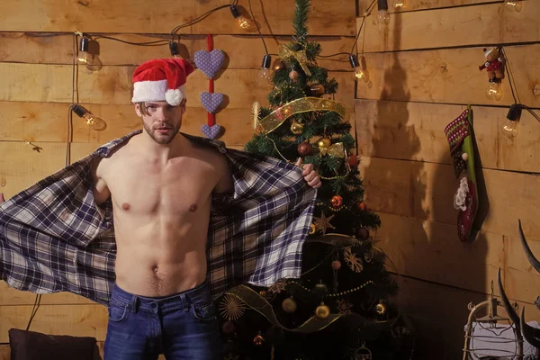 Kerst man op houten achtergrond met gespierde borst. — Stockfoto