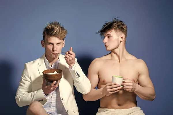 Twins with muscular body in jacket with cup and bowl. — Stock Photo, Image