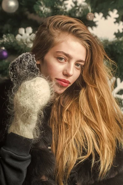 Рождественская женщина в зимней варежке держать мобильный телефон — стоковое фото