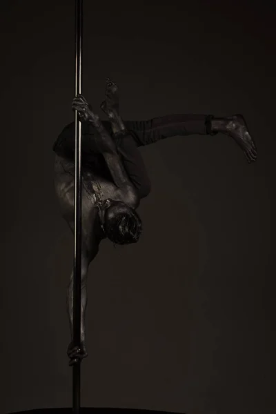 Jovem forte pole dance homem no fundo escuro . — Fotografia de Stock