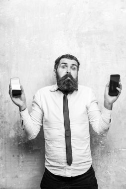 sakallı adam veya hipster karşılaştırmak hareket eden telefon ve smartphone