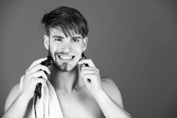 男剃毛毛電気シェーバーと安全カミソリの笑顔の顔 — ストック写真
