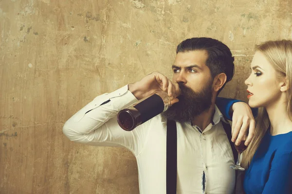 Mujer con vidrio mirando al hombre bebiendo vino de botella —  Fotos de Stock