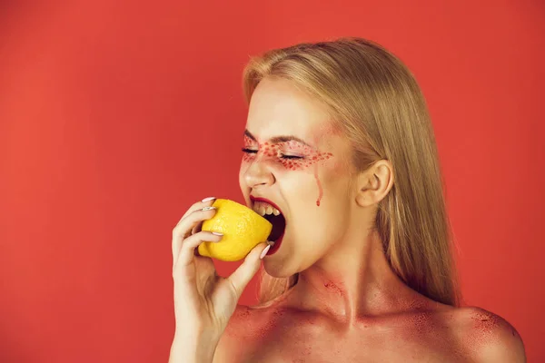 lemon in hand of woman with creative fashionable makeup, vitamin