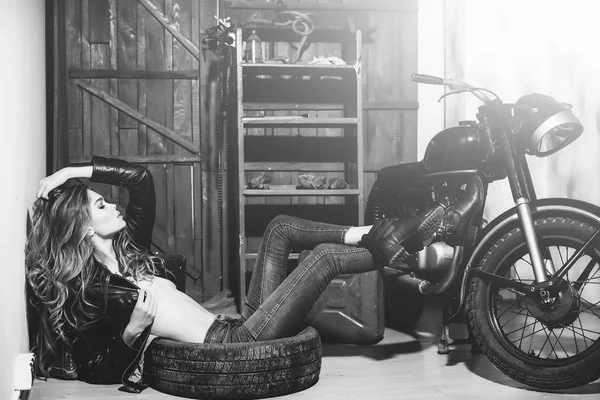 Sexy woman lying in dirty rubber tire on floor — Stock Photo, Image