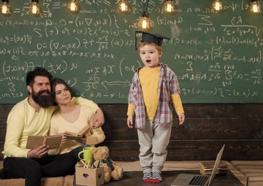 Çocuk Anne ve baba için onun bilgi sunma. Lisansüstü şapkalı akıllı çocuk gibi gerçekleştirmek. Kitap kara tahta arka plan ile hataları kontrol onların oğlu, dinleme anne. Sınav kavramı için hazırlanıyor.