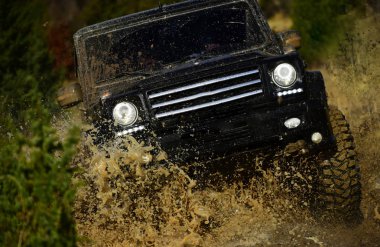 Rekabet, enerji ve motor sporları konsept. Yol araç veya kir sıçrama ile Suv geçiş su birikintisi. Sonbahar ormanda yarış araba. Otomatik Sonbahar Doğa arka plan üzerinde yarış
