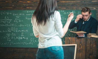 Öğretim adamış. Adam öğretmek kadın arka görünümü. Öğretmen ve kız öğrenci sınıfta. Üniversite veya ev okullaşma eğitimde. Muayene veya ders. Okula dönüş