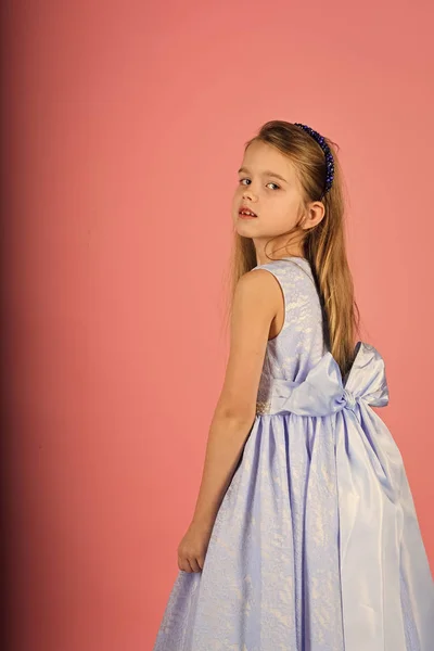 Kleines Mädchen in modischem Kleid, Abschlussball. Mode-Modell auf rosa Hintergrund, Schönheit. Mode und Schönheit, kleine Prinzessin. Look, Friseur, Make-up. Kindermädchen in stilvollem Glamour-Kleid, Eleganz. — Stockfoto