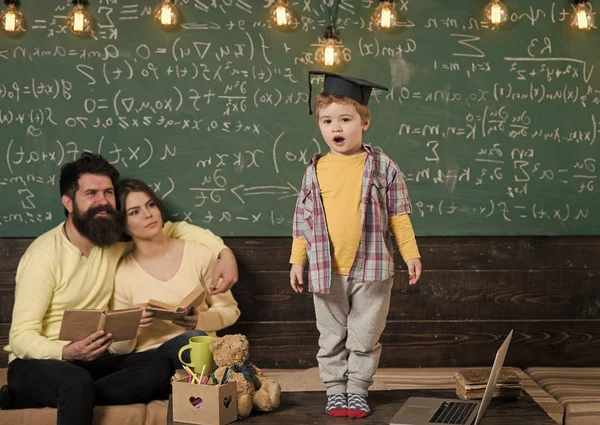 Çocuk Anne ve baba için onun bilgi sunma. Lisansüstü şapkalı akıllı çocuk gibi gerçekleştirmek. Kitap kara tahta arka plan ile hataları kontrol onların oğlu, dinleme anne. Sınav kavramı için hazırlanıyor.