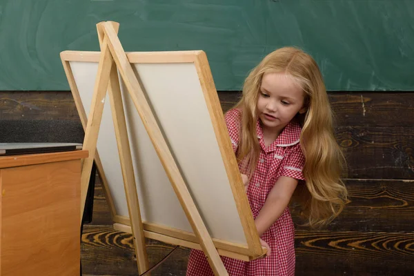 Маленький ребенок учится рисовать на мольберте. Я люблю рисовать. — стоковое фото