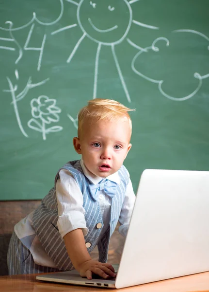 Il bambino usa il computer portatile nella vita moderna. La vita moderna con le nuove tecnologie nella scuola elementare — Foto Stock