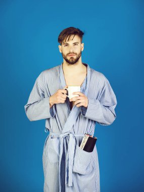 Yakışıklı adam cebinde holding Kupası ve dergi elbise içinde