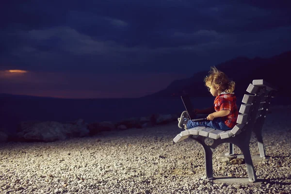 Cute boy with laptop on beach — Stock Photo, Image