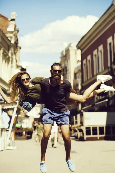 Vrouw op achterkant lachende bebaarde man springen — Stockfoto