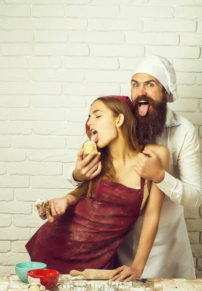 Baker feeds cakes to girl — Stock Photo, Image