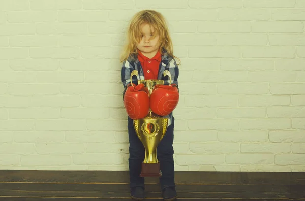 Kid wearing boxing glove, boy boxer winning golden champion cup — Stock Photo, Image