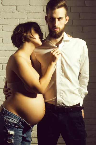 Barbudo hombre y bonita mujer embarazada con desnudo vientre redondo — Foto de Stock