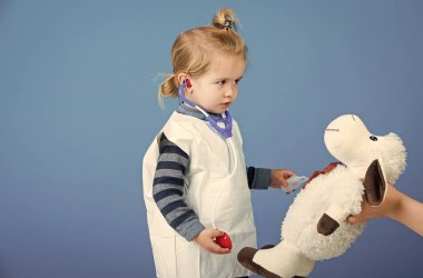 Çocuk anne elinde oyuncak koyun ile veteriner Doktor oynamak