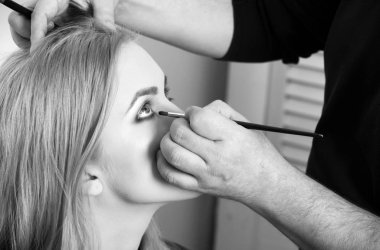 Kız yüz fırça ile göz makyajı uygulayarak Visagiste