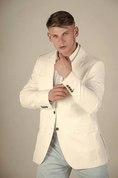 Model poseren in witte jas, gestreepte shirt en blauwe broek — Stockfoto